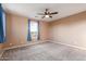 A bedroom with carpet, a ceiling fan, and a bright window with curtains at 2062 W Roy Rogers Rd, Phoenix, AZ 85085