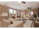Inviting living room featuring neutral tones, multiple windows, ceiling fans, and comfortable seating at 2062 W Roy Rogers Rd, Phoenix, AZ 85085