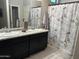 Bright bathroom featuring double sinks, granite countertops, and Parisian themed shower curtain at 22325 N 185Th Ave, Surprise, AZ 85387