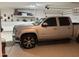 View of a clean garage featuring an epoxied floor, shelving and a silver pickup truck at 22325 N 185Th Ave, Surprise, AZ 85387