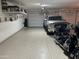 Clean garage featuring epoxied floors, overhead storage, a silver pickup truck and a motorcycle at 22325 N 185Th Ave, Surprise, AZ 85387