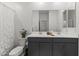 Well-lit bathroom with double vanity sinks, large mirror, and shower with patterned curtain at 22657 N 184Th Ln, Surprise, AZ 85387