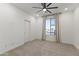 Neutral bedroom with large window providing natural light and a ceiling fan at 22657 N 184Th Ln, Surprise, AZ 85387