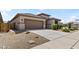 This single-story home has neutral color scheme, a two-car garage, and is complemented by gravel landscaping at 22657 N 184Th Ln, Surprise, AZ 85387