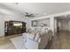 Open-concept living room featuring plush gray seating, a ceiling fan, and a view into the adjacent dining area at 22657 N 184Th Ln, Surprise, AZ 85387
