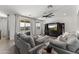 Bright living room with comfortable gray couches, a ceiling fan, TV, and a view of the pool from the window at 22657 N 184Th Ln, Surprise, AZ 85387