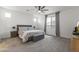 Bright main bedroom with a plush carpet, stylish bedding, ceiling fan, and abundant natural light at 22657 N 184Th Ln, Surprise, AZ 85387