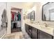 Modern bathroom featuring a dual sink vanity, square mirrors, and a walk-in closet, offering both style and functionality at 2746 E Fawn Dr, Phoenix, AZ 85042