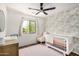 Charming Bedroom with floral wallpaper, a white crib, and a plush chair, creating a sweet and serene environment at 2746 E Fawn Dr, Phoenix, AZ 85042