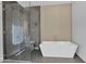 Modern bathroom featuring a glass shower and white soaking tub at 3718 E Sells Dr, Phoenix, AZ 85018