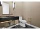 Stylish powder room featuring modern fixtures, and dark stone countertop and sink at 3718 E Sells Dr, Phoenix, AZ 85018