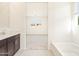 Bright bathroom showcasing a soaking tub, vanity with dark cabinets and access to the bedroom at 3805 N Camden Dr, Florence, AZ 85132