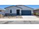 Charming single-story home showcasing a blue garage door and professionally landscaped front yard at 3805 N Camden Dr, Florence, AZ 85132