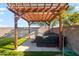 Backyard hot tub covered by a wooden pergola located on the putting green at 4143 E Sidesaddle Rd, San Tan Valley, AZ 85140