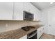 Modern kitchen boasts granite countertops, stainless steel appliances and white cabinets at 4143 E Sidesaddle Rd, San Tan Valley, AZ 85140