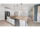 Open kitchen featuring an island with a stainless sink, granite countertops, and modern appliances at 4143 E Sidesaddle Rd, San Tan Valley, AZ 85140