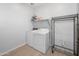 Bright laundry room with full-size washer, dryer, shelf, and storage rack at 4143 E Sidesaddle Rd, San Tan Valley, AZ 85140