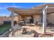 Backyard showcasing a covered patio, built-in fire pit, and outdoor dining area, perfect for entertaining at 671 W Jahns Ct, Casa Grande, AZ 85122