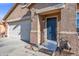 Close-up of the front entrance featuring a blue front door and a two-car garage at 671 W Jahns Ct, Casa Grande, AZ 85122