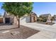 Cozy single-story home with a two-car garage, desert landscaping, and a mature shade tree at 671 W Jahns Ct, Casa Grande, AZ 85122