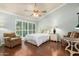 This bedroom features natural light, ceiling fan, hardwood floor, and comfortable furniture at 7324 S Bonarden Ln, Tempe, AZ 85283