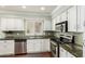 Clean kitchen featuring white cabinets, stainless appliances, and backsplash at 7324 S Bonarden Ln, Tempe, AZ 85283