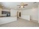 A bright living space featuring a ceiling fan, carpet, and an open layout to an adjacent kitchen at 854 S San Marcos Bldg 6 -- # A, Apache Junction, AZ 85120