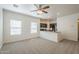 A bright living space featuring a ceiling fan, carpet, and an open layout to an adjacent kitchen at 854 S San Marcos Bldg 6 -- # A, Apache Junction, AZ 85120