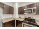 Kitchen featuring granite counters, microwave, and dark wood cabinetry at 854 S San Marcos Dr Bldg 6 Dr # D, Apache Junction, AZ 85120
