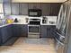 Well-equipped kitchen with stainless steel appliances, dark cabinets, and modern finishes at 8673 W Palm Ln, Phoenix, AZ 85037