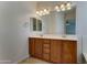 Bathroom vanity with double sinks, ample lighting, and wood cabinetry at 1120 W Desert Hollow Dr, San Tan Valley, AZ 85143