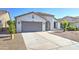 Charming single-story home with desert landscaping, covered entry, and gray two car garage door at 1120 W Desert Hollow Dr, San Tan Valley, AZ 85143