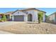 Charming single-story home with desert landscaping, covered entry, and gray two car garage door at 1120 W Desert Hollow Dr, San Tan Valley, AZ 85143
