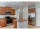 Open kitchen featuring center island, wood cabinetry, granite countertops, and stainless steel appliances at 1120 W Desert Hollow Dr, San Tan Valley, AZ 85143