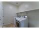 Bright laundry room features modern washer and dryer with built-in shelving at 1120 W Desert Hollow Dr, San Tan Valley, AZ 85143