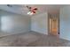 Serene main bedroom with soft carpet, ceiling fan, and easy access to the ensuite bathroom offers comfort and convenience at 1120 W Desert Hollow Dr, San Tan Valley, AZ 85143