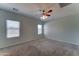 Carpeted main bedroom featuring a ceiling fan, neutral paint, and ample natural light to create a peaceful retreat at 1120 W Desert Hollow Dr, San Tan Valley, AZ 85143
