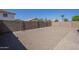 Large gravel-covered backyard is enclosed by a block fence, providing a private outdoor space at 12813 W Paradise Dr, El Mirage, AZ 85335