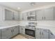 Updated kitchen with gray cabinets, stainless steel appliances, white quartz countertops, and hardwood flooring at 12813 W Paradise Dr, El Mirage, AZ 85335