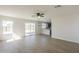 Open concept living room with vinyl flooring, ceiling fan, and views of the kitchen and backyard at 12813 W Paradise Dr, El Mirage, AZ 85335