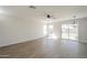 Spacious living room with vinyl flooring, ceiling fan, recessed lighting, and sliding glass doors to the backyard at 12813 W Paradise Dr, El Mirage, AZ 85335