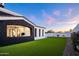 Backyard with lush artificial grass, black stone archway, and desert landscaping at 13074 E Saddlehorn Trl, Scottsdale, AZ 85259