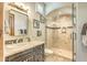 A charming bathroom with a glass shower, stone tile, and vanity at 13074 E Saddlehorn Trl, Scottsdale, AZ 85259