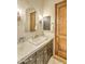 Bathroom with stone countertop, unique mirror, and wood door at 13074 E Saddlehorn Trl, Scottsdale, AZ 85259