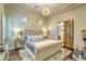 An airy bedroom with a tufted headboard, decorative chandelier, and en-suite bathroom access at 13074 E Saddlehorn Trl, Scottsdale, AZ 85259