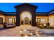 Inviting outdoor courtyard with a fireplace, comfortable seating, and grand archway at 13074 E Saddlehorn Trl, Scottsdale, AZ 85259