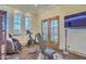 Bright exercise room offers modern workout equipment, floor-to-ceiling windows, French doors, and a sleek TV screen at 13074 E Saddlehorn Trl, Scottsdale, AZ 85259