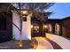 An inviting home entrance with a stone archway, custom gate, and landscaped pathway at 13074 E Saddlehorn Trl, Scottsdale, AZ 85259