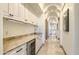 Hallway wet bar features marble countertops, a beverage fridge, and custom cabinetry for a seamless entertainment experience at 13074 E Saddlehorn Trl, Scottsdale, AZ 85259
