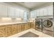 Laundry room with white cabinets, stone countertops, and stainless steel appliances at 13074 E Saddlehorn Trl, Scottsdale, AZ 85259